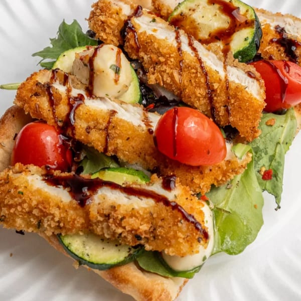 Crispy chicken cutlets, zucchini, cherry tomatoes, and mozzarella on a flatbread with balsamic glaze.